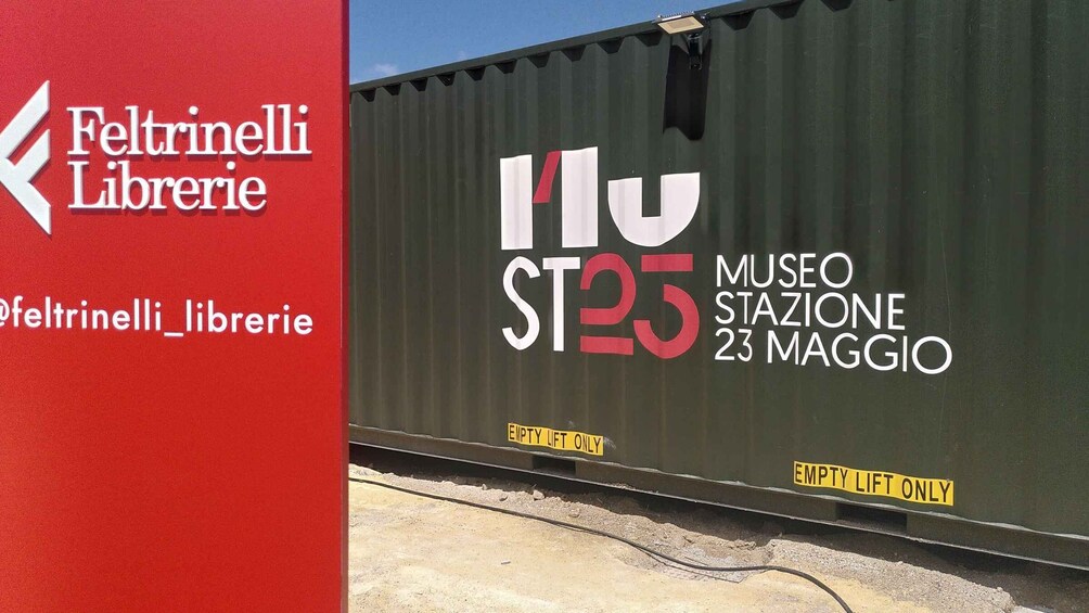 A red and green container with 'Feltrinelli Libri' and 'MUSEO ST25' text, indicating a library and museum event. 2