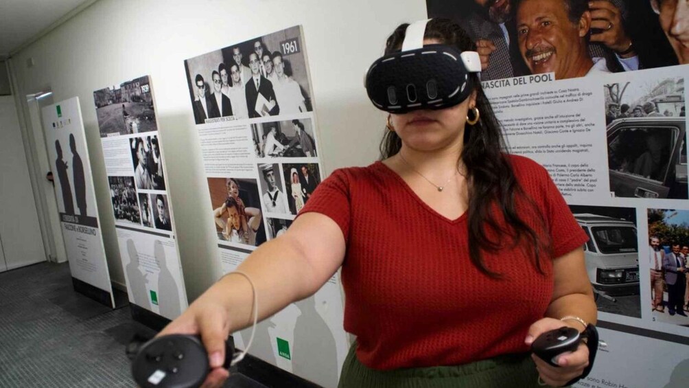 A person wearing a VR headset, holding a controller, in front of a wall with historical photos and text. 1