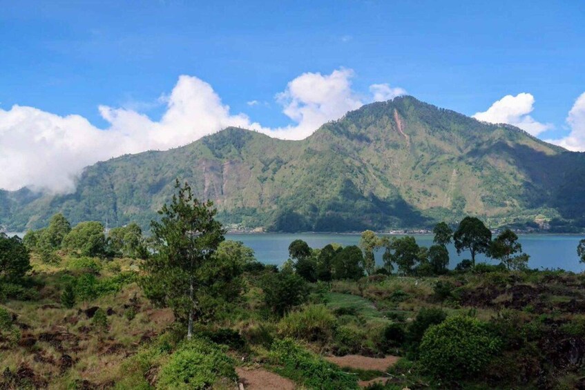 A mountainous landscape with a lake and scattered trees. 3