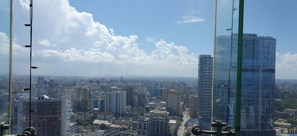 A cityscape with tall buildings, a clear sky, and scattered clouds. 5