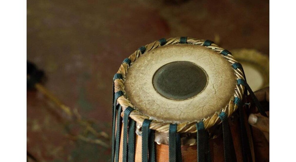 A close-up of a drum with a circular head and a rope-bound rim. 4