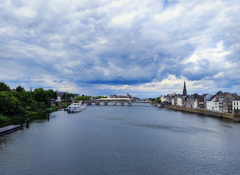 A river with a bridge, a boat, and historic buildings along the banks. 3