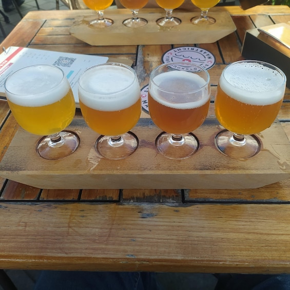 Four glasses of beer on a wooden tray. 2