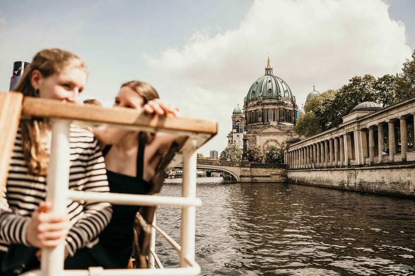A river with a bridge and a large dome-like building in the background. 2