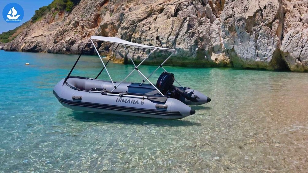 Ein HIMALAYA 6 Schlauchboot auf klarem türkisblauem Wasser, im Hintergrund felsige Klippen. 1