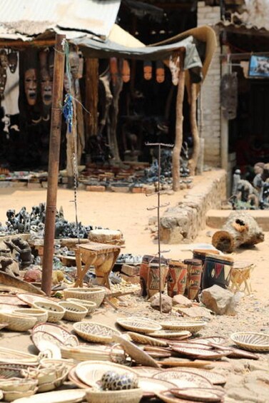 A market with various items like baskets and pottery displayed on the ground. 2