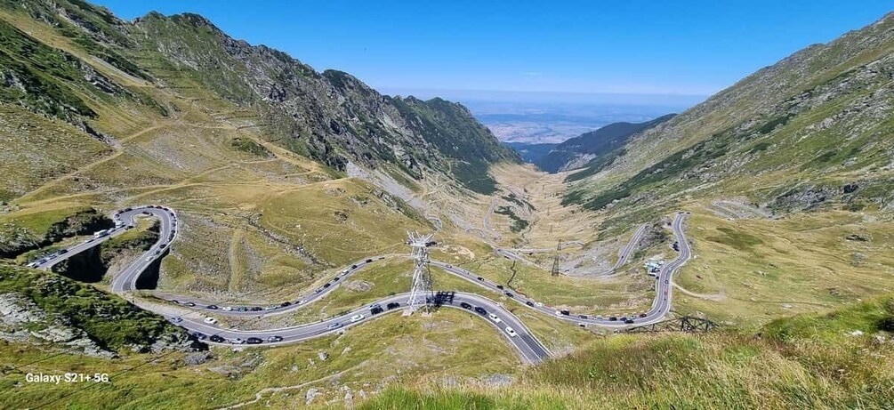 A winding mountain road with multiple lanes and a central service road. 1