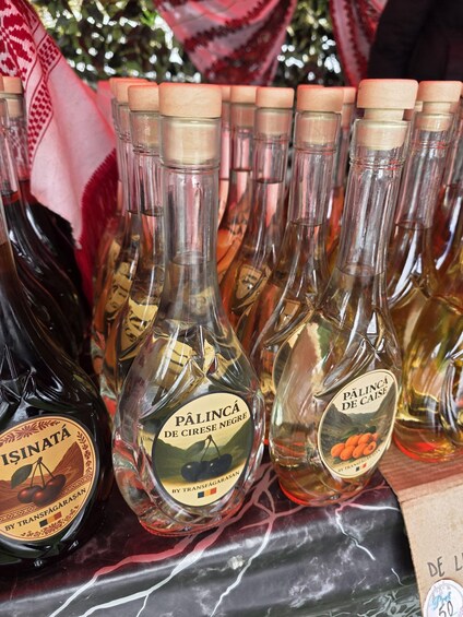 A display of Pálinca de Círese Negre bottles with labels, arranged on a table. 3