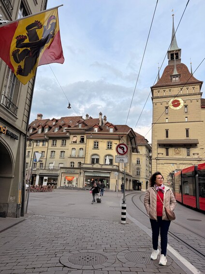 A street scene with a tram, a flag, and historic buildings. 5