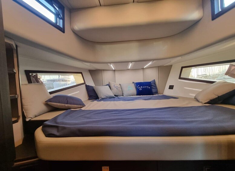 A compact, well-lit interior with a bed, pillows, and a window. 2