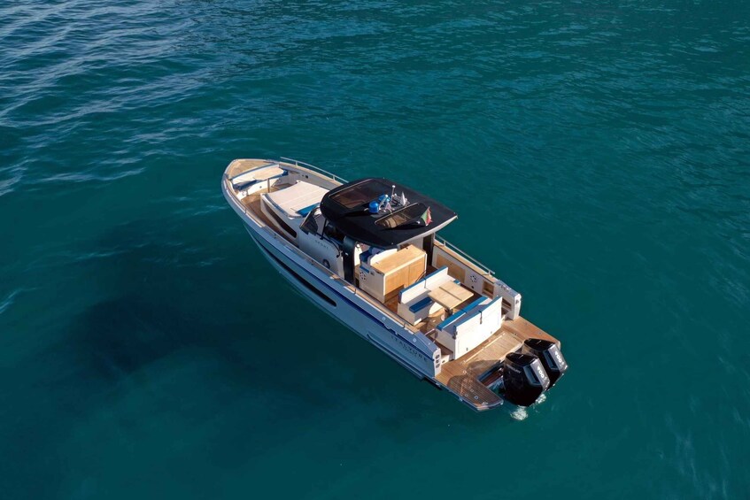 A motorboat with a cabin and deck seating, floating on clear blue water. 4