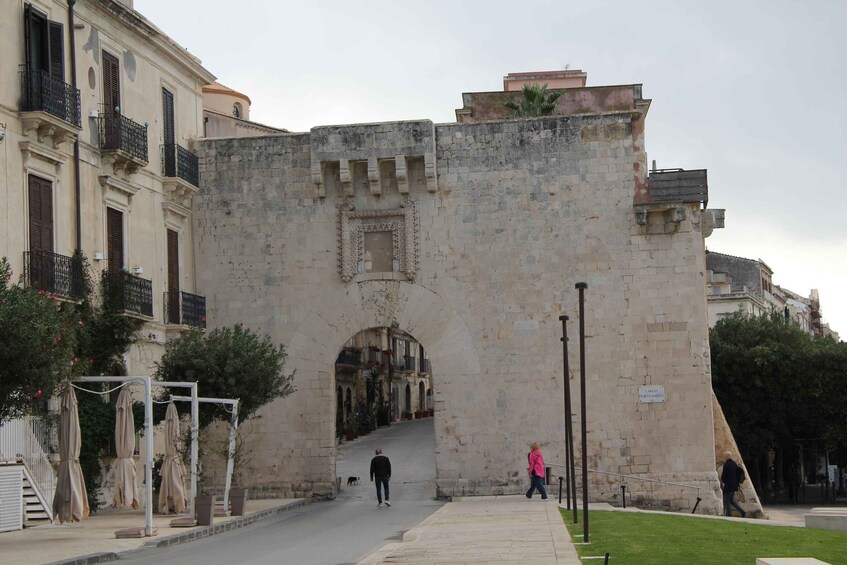 A stone archway with a sign reading 'Largo de la Marina' in a city setting. 5