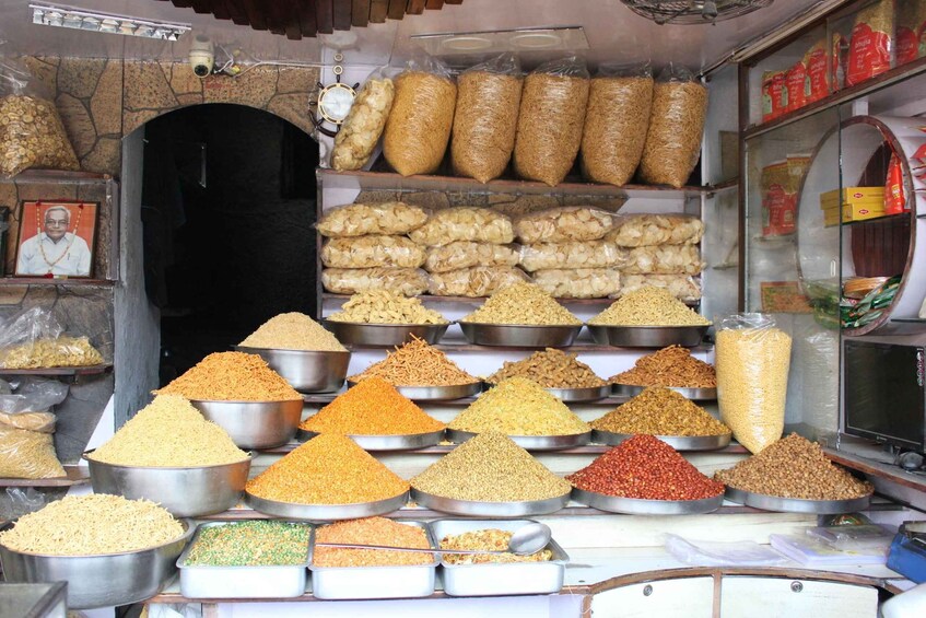 A variety of grains and legumes displayed in metal containers and bags. 3