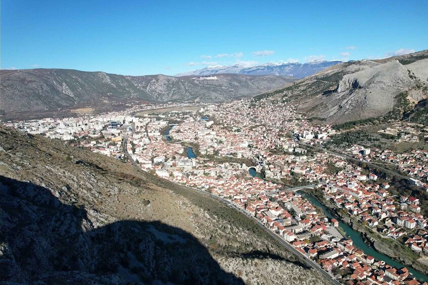 A mountainous town with a river winding through it. 2