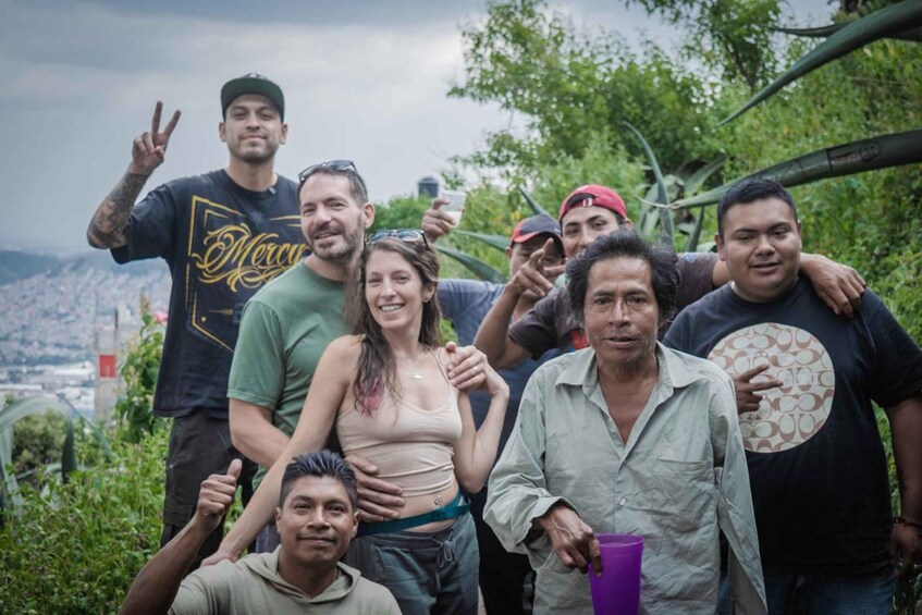 A group of people outdoors with greenery and a distant cityscape in the background. 5