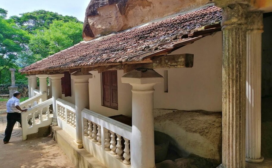 A traditional building with a tiled roof, white columns, and a balcony with balustrades. 5