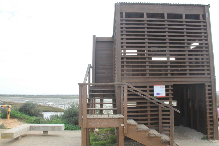A wooden structure with a staircase leading to a platform overlooking a body of water. 2