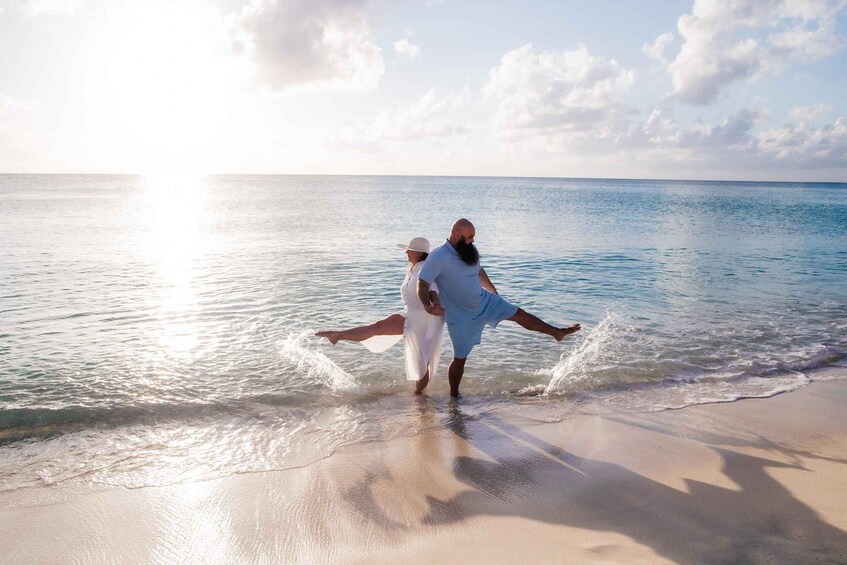 A couple dancing on a beach with the ocean in the background. 2