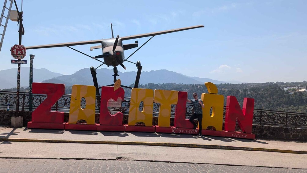 A sign with the word 'ZACELIN' and a helicopter in the background. 1