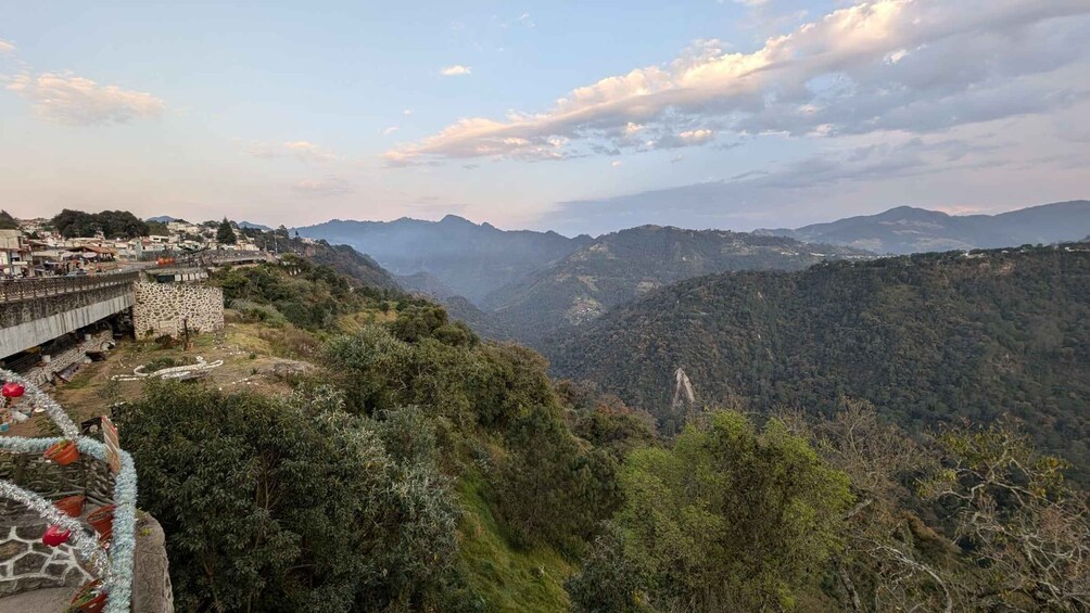 A mountainous landscape with a bridge and a town on the left. 3