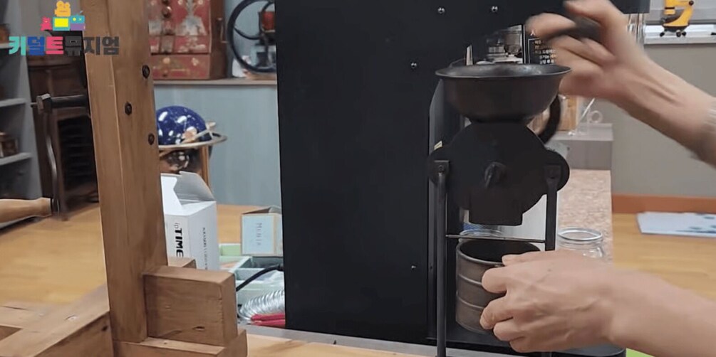 A person operating a coffee machine, with a cup in hand. 5