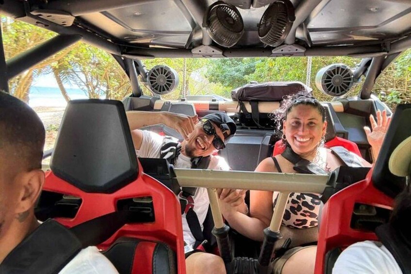 A vehicle interior with passengers, a beach view, and a tropical environment. 2
