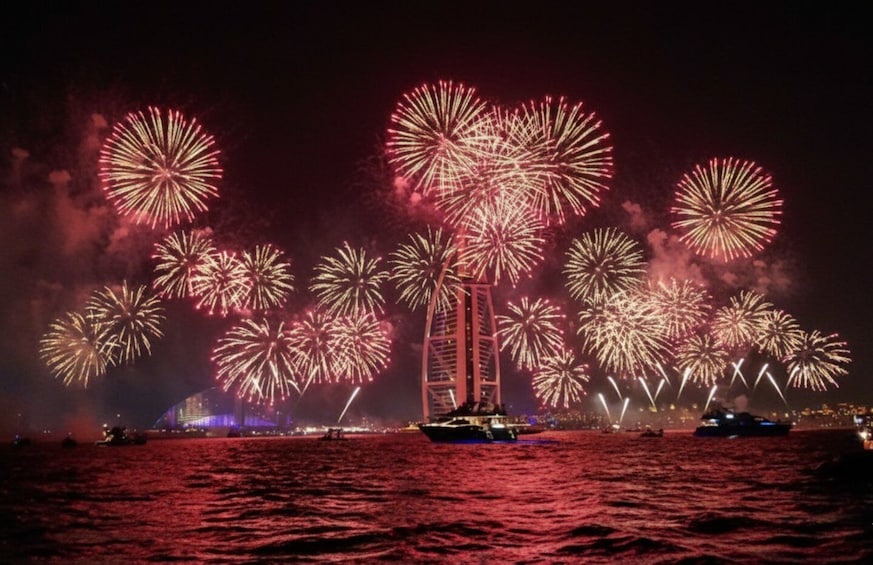 A sailboat on water with fireworks in the background. 5