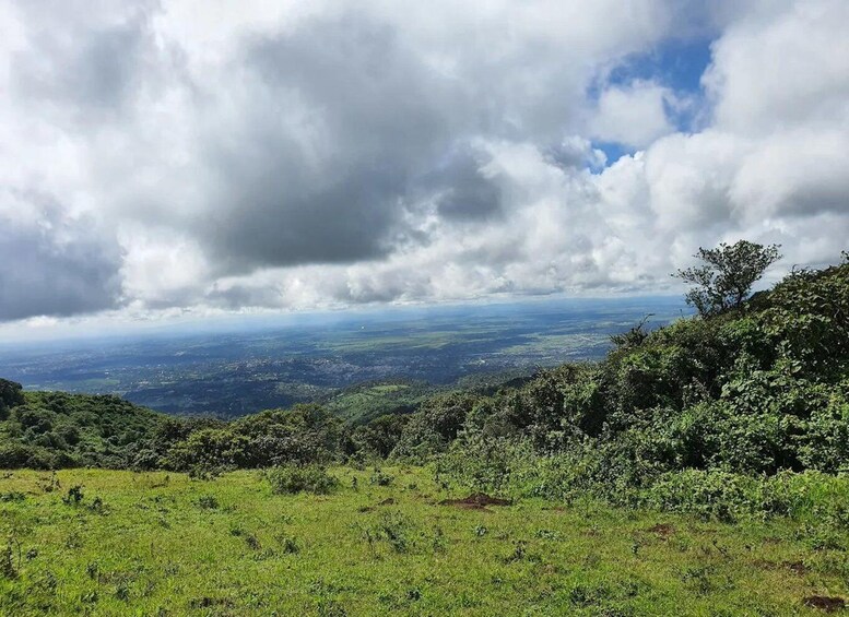 A lush green landscape with a view of distant hills and a cloudy sky. 5