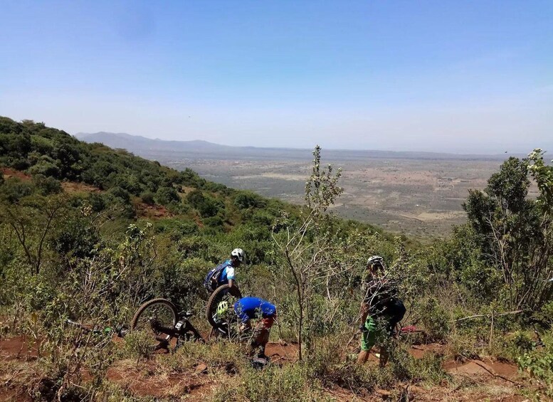 Mountain bikers on a trail with a view of a valley and distant mountains. 3