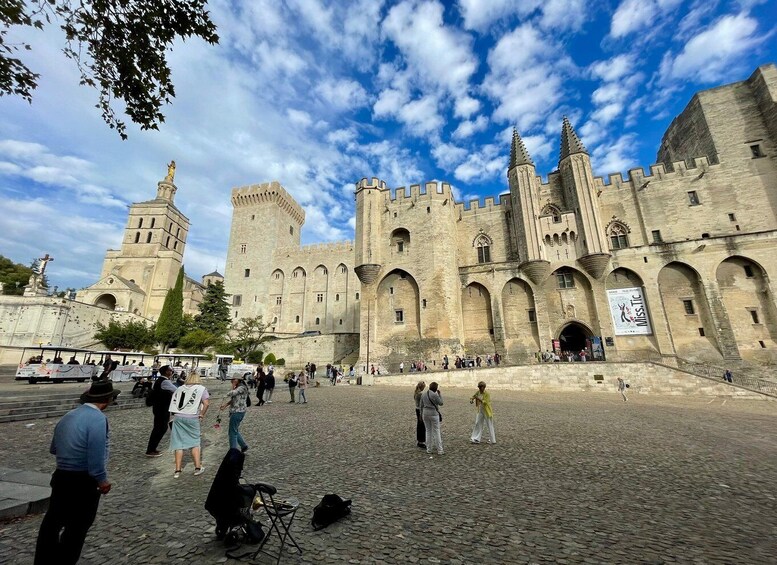 A historic castle with a large courtyard, tourists, and a clear sky. 5