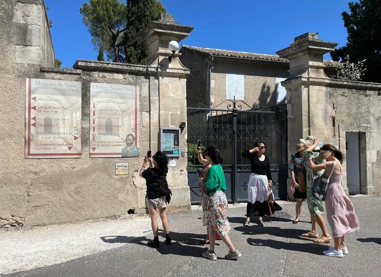 A group of people taking photos in front of a building with historical plaques. 3