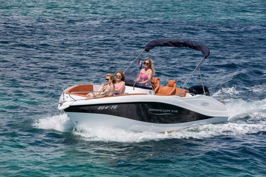 A speedboat with three passengers on a calm sea. 3
