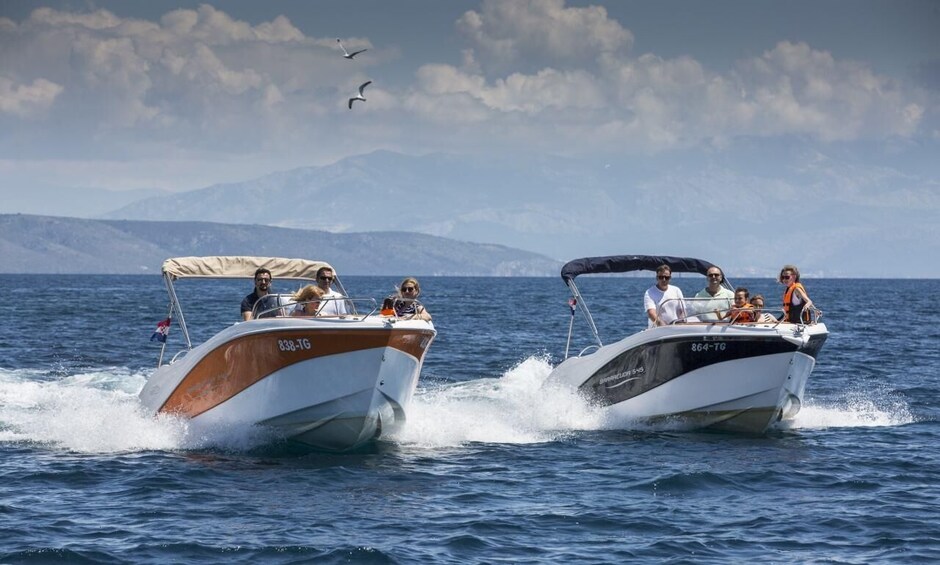 Two motorboats on a calm sea with mountains in the background. 5
