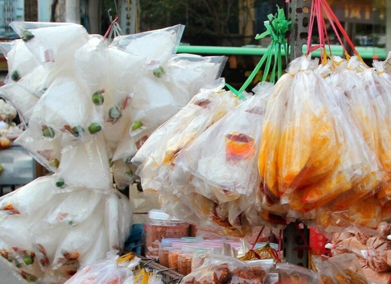 Plastic bags filled with various food items hanging outdoors. 5