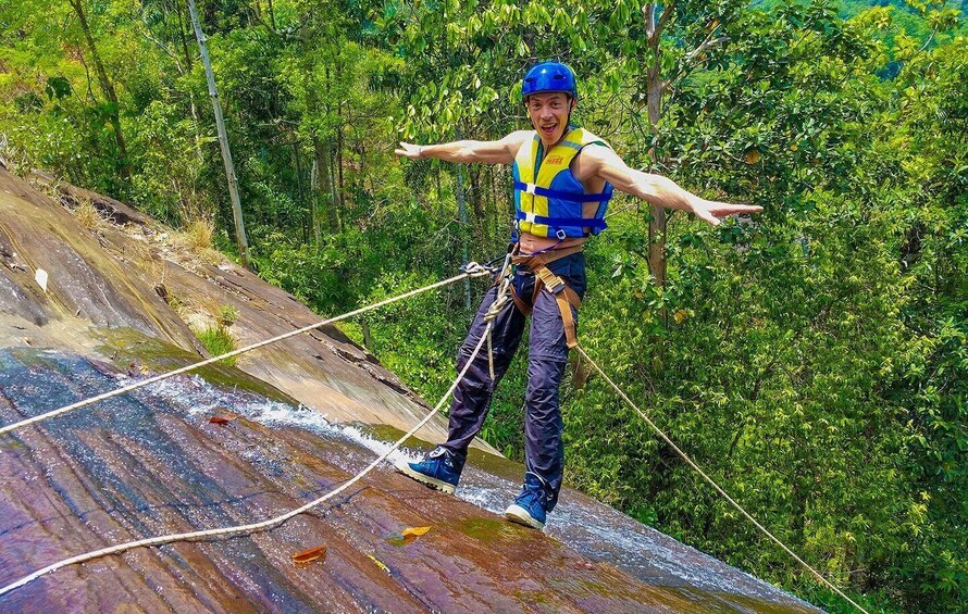 A person bungee jumping from a wooden platform with ropes, surrounded by dense green foliage. 3