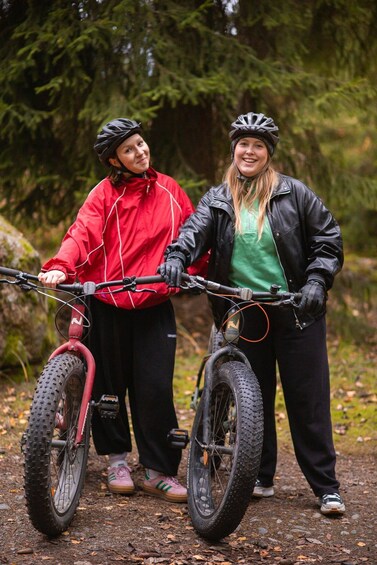 Two people on bicycles in a forested area. 2