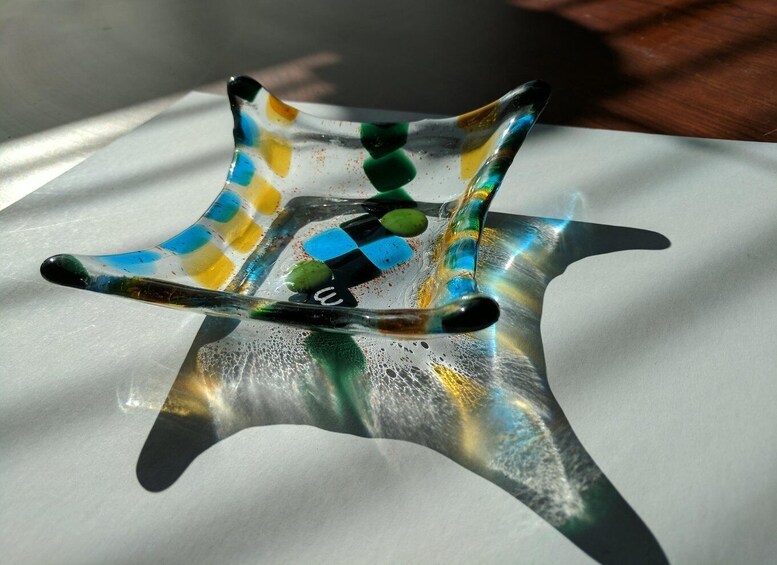 A glass art piece with a starfish design and multicolored patterns. 2