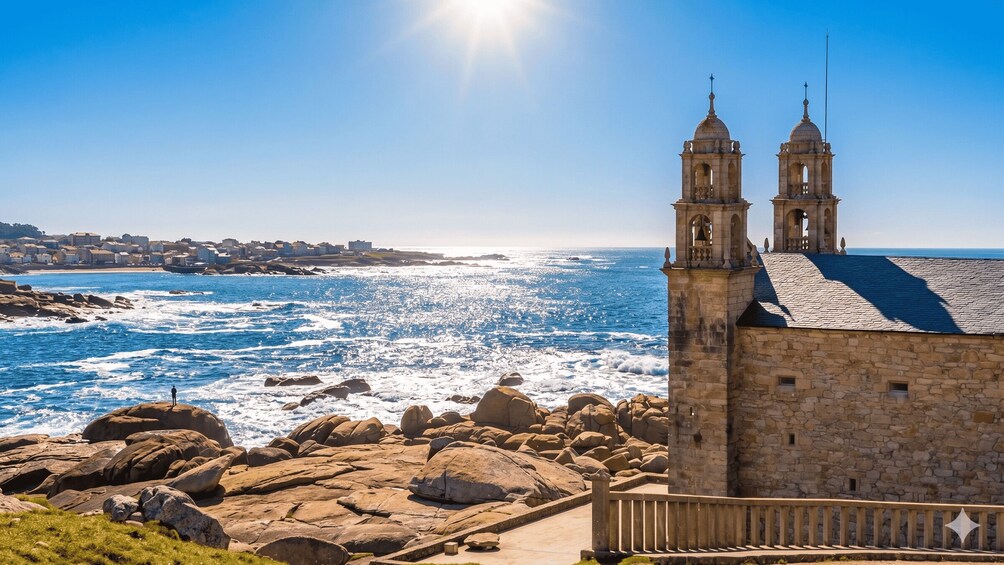 A coastal town with a prominent stone church featuring two bell towers, overlooking a rocky shoreline with waves crashing against the rocks. 5