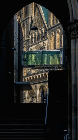 An arched bridge with a glass walkway over a historic building with arches and detailed stonework. 5
