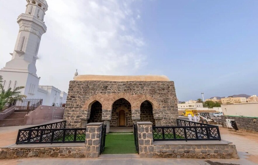 A mosque with a minaret and a stone entrance. 2