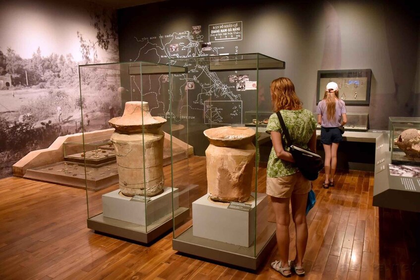 A museum exhibit with ancient pottery and a map on the wall. 1