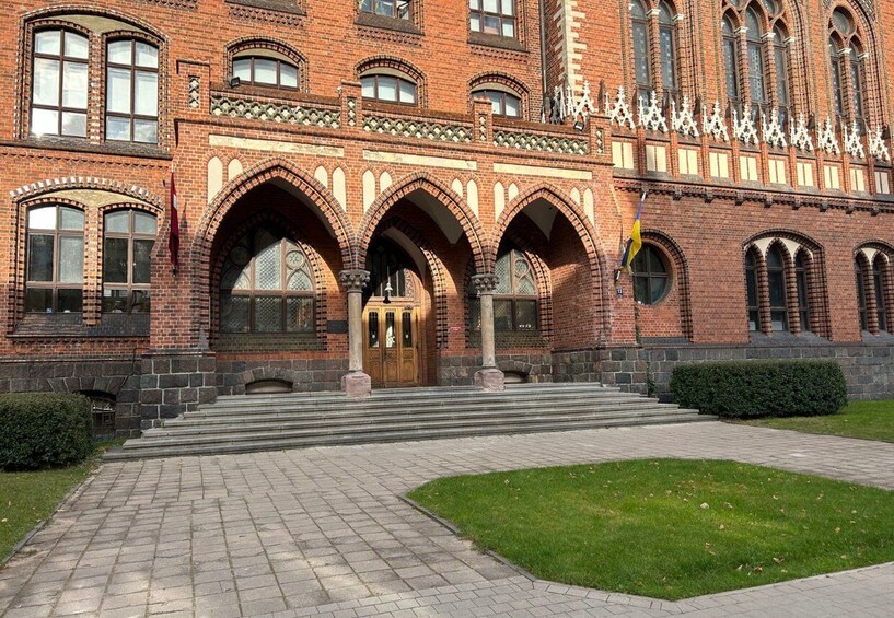 A red brick building with arched windows and a central entrance. 4