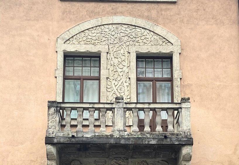 A building facade with a decorative window and a stone balustrade. 5