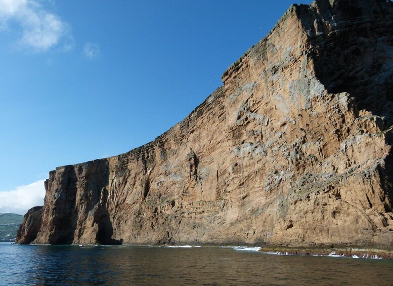 A large cliff by the sea with clear blue sky. 2