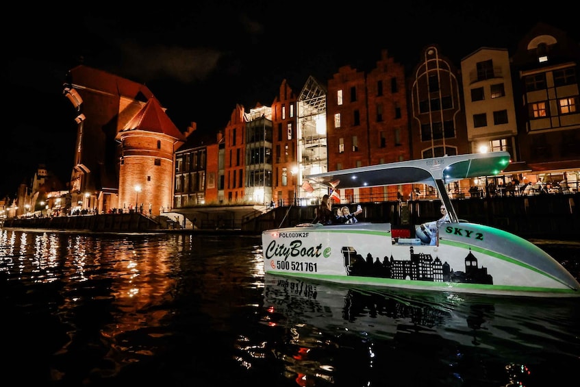 A nighttime boat tour with illuminated buildings in the background. 3