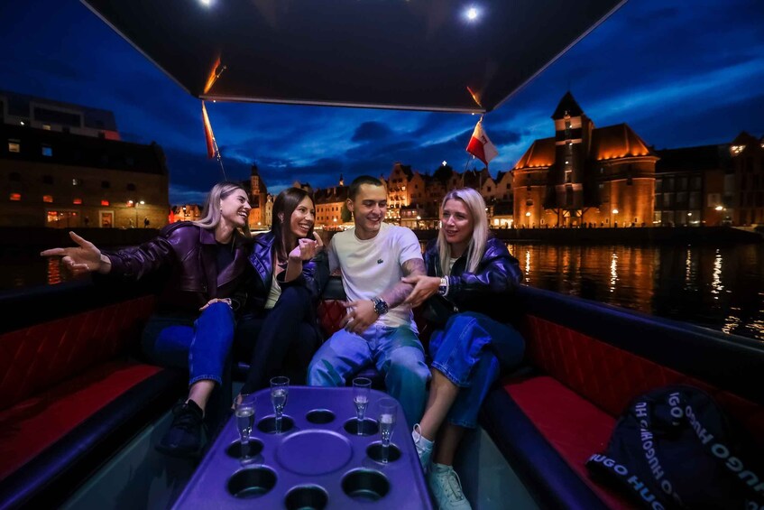 A group of people on a boat with a cityscape in the background. 5