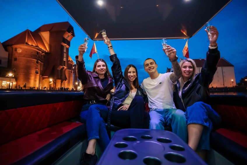 A group of people on a boat with a cityscape in the background. 1