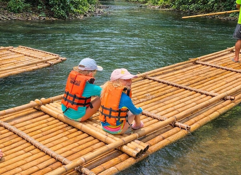 Two people on a bamboo raft in a river. 3