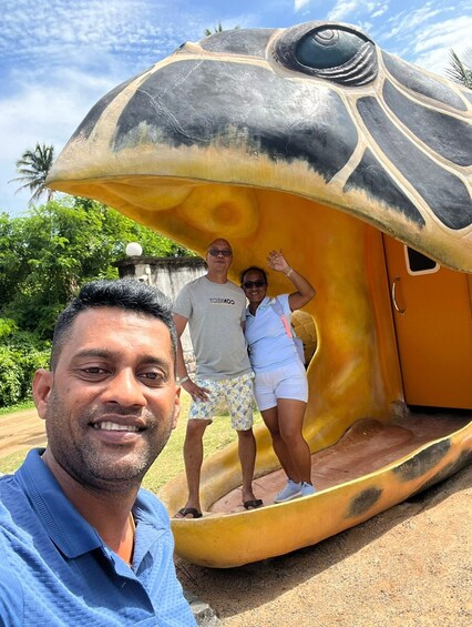 A large, colorful sculpture resembling a turtle with a person standing on its back. 3
