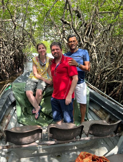 Three people on a boat in a mangrove area. 4